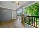 A serene, covered back porch with wood floors, string lights, and a beautiful view of mature trees at 1307 Madison Se Ln, Smyrna, GA 30080