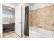 Bathroom with tub and shower combo, tiled wall and a view into the bedroom at 200 River Vista Dr # 502, Atlanta, GA 30339