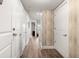 Hallway with light wood floors and wood accent wall, leading towards a bright room with a view at 200 River Vista Dr # 502, Atlanta, GA 30339