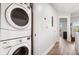 Hallway laundry area with stacked washer and dryer and wood look flooring at 200 River Vista Dr # 502, Atlanta, GA 30339