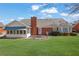Spacious backyard showcasing a sunroom addition and well-manicured lawn at 223 Ivy Creek Dr, Loganville, GA 30052