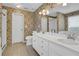 This bathroom has dual sinks and a floral wallpaper design at 223 Ivy Creek Dr, Loganville, GA 30052