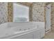 A soaking tub with jets sits below a large window in this bathroom at 223 Ivy Creek Dr, Loganville, GA 30052
