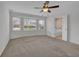 This carpeted bedroom features a ceiling fan, and a view of the back yard at 223 Ivy Creek Dr, Loganville, GA 30052