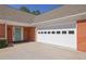 Attached two-car garage with a light blue front door and a red brick wall at 223 Ivy Creek Dr, Loganville, GA 30052