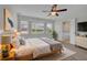 This carpeted main bedroom features a ceiling fan, and a view of the back yard at 223 Ivy Creek Dr, Loganville, GA 30052