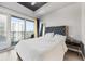Bright bedroom with a balcony offering city views, features a tufted headboard and neutral decor at 250 Pharr Ne Rd # 1702, Atlanta, GA 30305