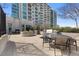 Outdoor patio with grill, fireplace, seating, and string lights, set against a high-rise building backdrop at 250 Pharr Ne Rd # 1702, Atlanta, GA 30305