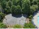Aerial of a community basketball court with mature tree landscaping and a pool with lounge chairs in the distance at 3258 Welmingham Sw Dr, Atlanta, GA 30331