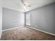 This bedroom includes neutral walls and carpet, bright natural light from the window, and a ceiling fan at 3258 Welmingham Sw Dr, Atlanta, GA 30331