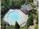 Aerial view of a large community pool, hot tub, sun chairs, and bath house surrounded by mature trees at 3258 Welmingham Sw Dr, Atlanta, GA 30331