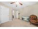 Bedroom with ceiling fan, view into the bathroom, a large tv, and an upholstered armchair at 165 Babbling Brook, Mcdonough, GA 30252