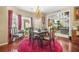 Dining room area with dark wood table and ornate chairs set over a magenta rug at 165 Babbling Brook, Mcdonough, GA 30252