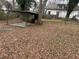Backyard with dead leaves and a metal pavilion with a concrete floor and BBQ at 211 Wellington Sw St, Atlanta, GA 30314