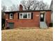 Charming red brick home with a chimney, black shutters, and an attached garage at 211 Wellington Sw St, Atlanta, GA 30314