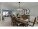 Spacious dining area with carpet, featuring a wooden table set for six, a chandelier, and seamless flow into the living space at 4330 Landover Nw Way, Suwanee, GA 30024