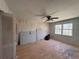 Bedroom with hardwood floors, ceiling fan, and a large window; needs renovations at 4625 Orkney Sw Ln, Atlanta, GA 30331
