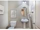 Half bath features neutral walls, pedestal sink, and decorative mirror and prints at 2474 Whiteoak Se Run # 18, Smyrna, GA 30080