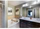 Well-lit bathroom featuring a soaking tub, double vanity with white countertops, and tiled shower at 2474 Whiteoak Se Run # 18, Smyrna, GA 30080