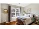 Cozy bedroom with natural light, hardwood floors, a patterned bedspread, and a window at 2474 Whiteoak Se Run # 18, Smyrna, GA 30080