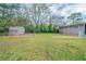 Expansive backyard featuring green grass, mature trees and storage shed at 3680 Brookcrest Cir, Decatur, GA 30032