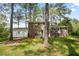 Backyard featuring a lawn, mature trees, and a side-entry garage attached to the house at 3973 Elmscourt Dr, Stone Mountain, GA 30083