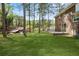 Expansive backyard featuring a lush lawn, mature trees, and a brick patio perfect for outdoor entertaining at 3973 Elmscourt Dr, Stone Mountain, GA 30083