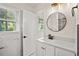 Bathroom featuring a round mirror, vanity sink, and marble tiled wall at 3973 Elmscourt Dr, Stone Mountain, GA 30083