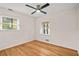 Bright bedroom featuring hardwood floors, a ceiling fan, and natural light from two windows at 3973 Elmscourt Dr, Stone Mountain, GA 30083