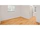 Bedroom featuring hardwood floors with white walls, window, and view to hallway with bathroom access at 3973 Elmscourt Dr, Stone Mountain, GA 30083