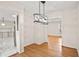 Open concept dining area with modern chandelier and hardwood floors, adjacent to kitchen at 3973 Elmscourt Dr, Stone Mountain, GA 30083