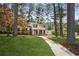 Well-maintained two-story home with a sidewalk leading to a yellow front door, surrounded by mature trees at 3973 Elmscourt Dr, Stone Mountain, GA 30083