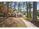 Well-maintained two-story home with a sidewalk leading to a yellow front door, surrounded by mature trees at 3973 Elmscourt Dr, Stone Mountain, GA 30083