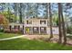 Well-maintained two-story home with a sidewalk leading to a yellow front door, surrounded by mature trees at 3973 Elmscourt Dr, Stone Mountain, GA 30083