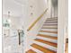Bright stairway featuring hardwood steps, a white riser, and a stained handrail leading to the upper level of the home at 3973 Elmscourt Dr, Stone Mountain, GA 30083