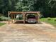 Picture of a carport featuring a wood frame and concrete floor, providing covered parking for a vehicle at 4424 Lower Fayetteville Rd, Sharpsburg, GA 30277