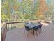 A patio set on a brown wooden deck with trees and landscaping in the background at 4424 Lower Fayetteville Rd, Sharpsburg, GA 30277