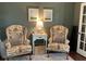Cozy sitting room featuring two patterned armchairs, a table, and decor at 4424 Lower Fayetteville Rd, Sharpsburg, GA 30277