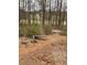 Concrete bench in a natural setting of trees and landscaping with a small gravel path at 4424 Lower Fayetteville Rd, Sharpsburg, GA 30277