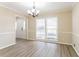 Elegant dining room with modern lighting fixture, neutral walls, and stylish wood-look floors at 4641 Waterford Ct, Atlanta, GA 30338