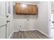 Well-lit laundry room featuring wood cabinets, modern flooring, and neutral paint at 4641 Waterford Ct, Atlanta, GA 30338