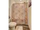 Well-lit bathroom with floral shower curtain and light gray wood-look floors at 534 Magnolia Cir, Palmetto, GA 30268