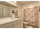 Bright bathroom featuring white vanity and cabinet with a floral shower curtain at 534 Magnolia Cir, Palmetto, GA 30268
