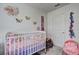 Bright Bedroom featuring a crib, decor, and soft gray carpeting at 534 Magnolia Cir, Palmetto, GA 30268