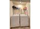 Convenient laundry room equipped with a washer, dryer, and shelving for storage solutions at 534 Magnolia Cir, Palmetto, GA 30268