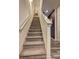 Well-lit carpeted staircase with white railings, leading to the upper level of the home at 534 Magnolia Cir, Palmetto, GA 30268