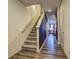 Carpeted staircase with white banisters and modern wood-look flooring, leading to the upper level at 534 Magnolia Cir, Palmetto, GA 30268