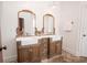 Bathroom with a double vanity, framed mirrors, and warm lighting adding a touch of elegance at 774 Forrester Cemetery Rd, Covington, GA 30014