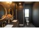 Elegant bathroom featuring double vanity sinks, striking round mirrors, and a walk-in shower at 774 Forrester Cemetery Rd, Covington, GA 30014