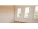 An unfurnished bedroom with new laminate flooring with views through three bright sunny windows at 774 Forrester Cemetery Rd, Covington, GA 30014